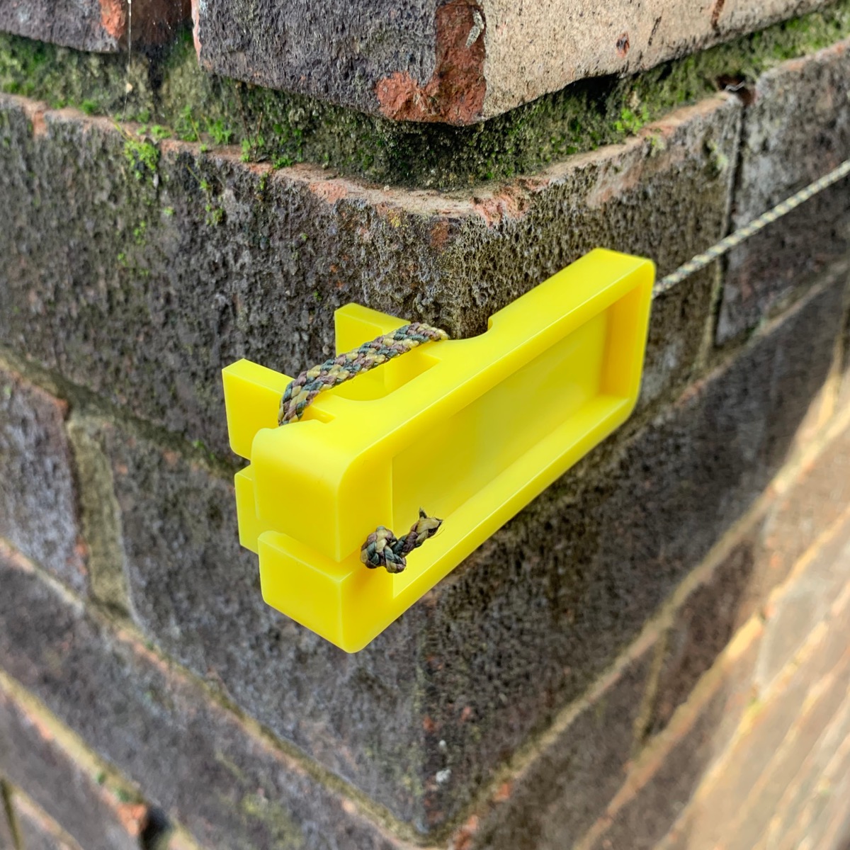 Create an even brick or block course with line blocks. Secure the 3-3/8" block on the outside corners of your masonry project with the line knotted to hold it in place.